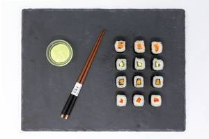 Aufsicht von japanischem Moso-Maki Sushi mit Wasabi und traditionellen Essstäbchen