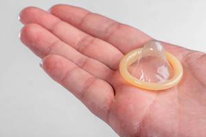 Ausgepacktes Kondom auf der Hand eines Mannes