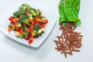Ausgewogenes Essen mit Brokkoli, Paprika, Möhren und braunen Fusilli-Nudeln