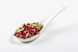 Australian green tea with flowers in a spoon on a white background (Flip 2020)