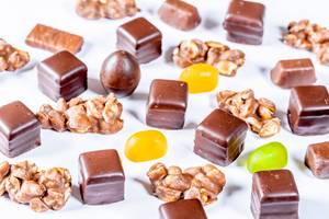 Auswahl von Pralinen, Süßigkeiten mit Schokoladenüberzug und Fruchtgummis auf weißem Hintergrund