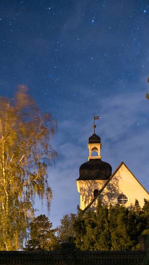 Authentic German protestant church at night with the starry sky above it