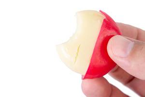 Babybel cheese in the hand above white background (Flip 2019)