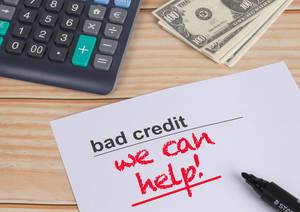 Bad Credit, we can help text with money and calculator on wooden table