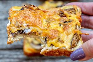 Baked sandwich with mushrooms and cheese in the hand of a woman (Flip 2019)