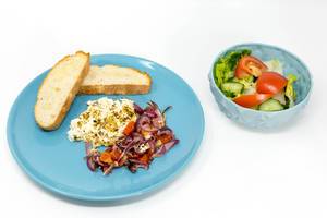 Baked shepherds cheese with tomatoes-onion stew and garlic bread on a blue plate and a fresh mixed salat on white background