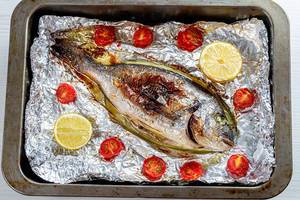 Baked with vegetables Dorado fish on foil in a baking sheet (Flip 2019)