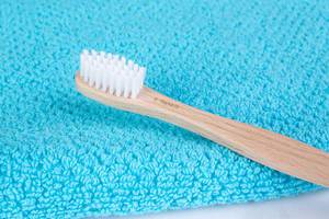 Bambus-Zahnbürste auf einem blauen Handtuch