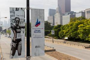 Banners of the 2019 Chicago Marathon with female athlete, logo, sponsors and road in the background