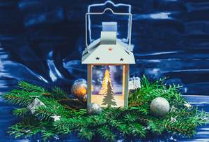 Beautiful Christmas background with a luminous lantern and branches of a Christmas tree. New year mood