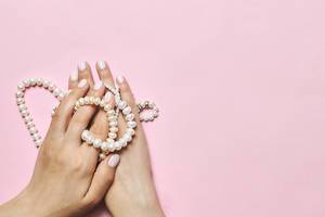 Beautiful female hands with manicure holding pearls (Flip 2020)