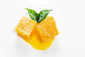 Bee honeycomb and honey with fresh green tea leaves