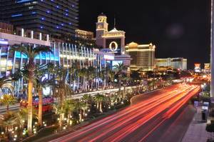 Beleuchtete Straße in der Casinostadt Las Vegas, Strip mit Lichtern unter den Palmen am Straßenrand