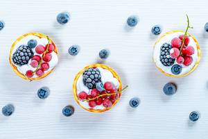 Berry cakes on a white wooden background. Top view (Flip 2019)