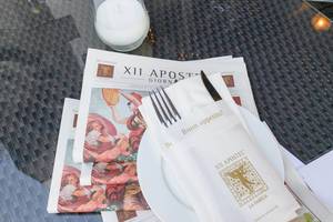 Besteck in einer Serviette, Teller und Zeitung im XII Apostel Albergo Hotel