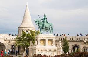 Besucher erkunden die neoromanische Fischerbastei in Budapest mit der Statue von St. Stephan