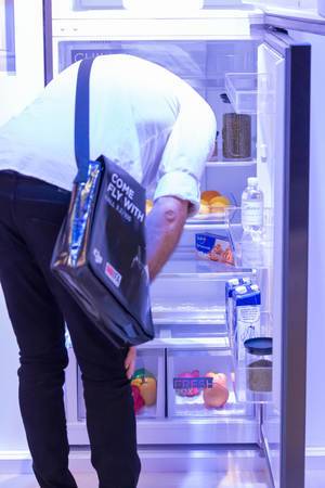 Besucher schaut sich einen digitalen, smarten Kühlschrank an
