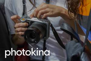 Besucher testen eine Hasselblad Kamera neben der Bildaufschrift "photokina"