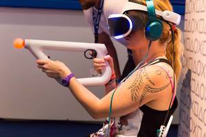 Besucherin verwendet den PlayStation VR aim Kontroller - Gamescom 2017, Köln