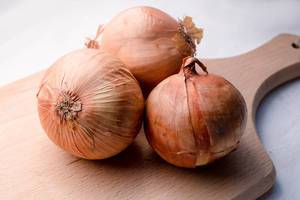Big raw onions ready to cut on a chopping board