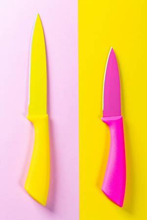 Big yellow and a little pink knife on a colored background