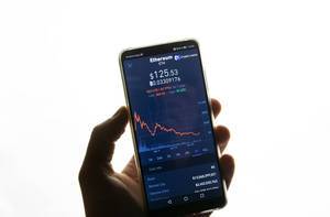 Bildschirm eines Smartphones zeigt Ethereum (ETH) Marktwert vor weißem Hintergrund