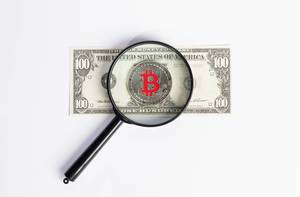 Bitcoin and magnifying glass