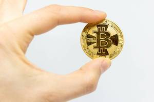 Bitcoin in a hand and white background