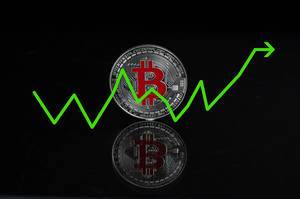 Bitcoin Wachstumsrate als Konzept mit einer silbernen Bitcoin-Münze auf schwarzem Hintergrund