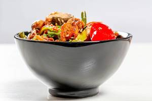 Black bowl full of Chinese buckwheat noodles with vegetables and tuna