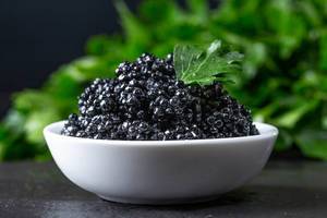 Black caviar in a white bowl