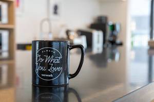 Black cup with coffee at a coworking office for independent entrepreneurs: Always do what you love by WeWork