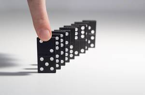 Black Dominos are getting started with a finger on a white background
