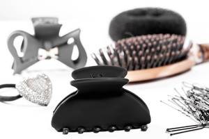 Black hair clips and hair bands with hairbrush on white background