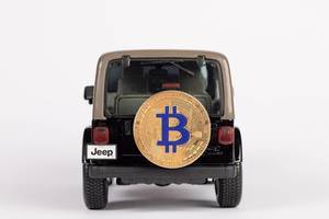 Black SUV car carrying Bitcoin on the back of the car