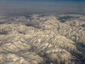 Blick auf die Alpen durch das Flugzeugfenster