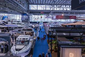 Blick über Ausstellungshalle mit Luxusjachten und Motorbooten mit interessierten Besuchern