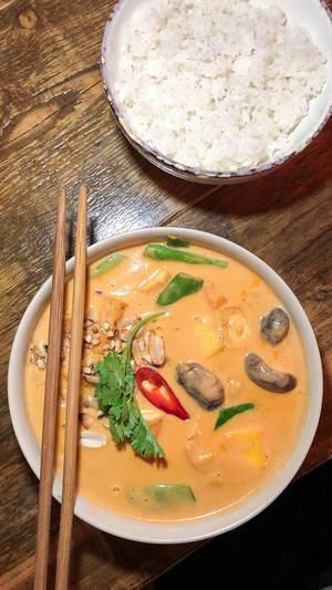 Blick von oben auf scharfes Chum Chay, Bio-Tofu in rotem Kokoscurry mit Mango und Reis