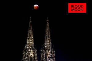 Blood Moon: Shadow eclipse with full red moon over German Cathedral in Cologne