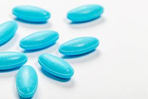 Blue antibiotic pills on white background
