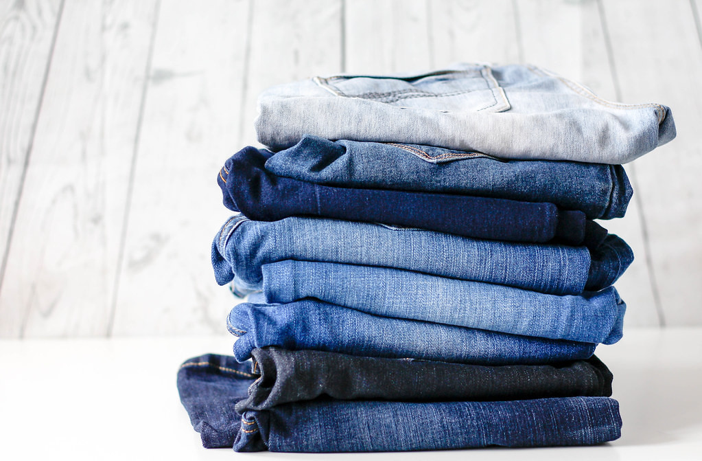 Blue jeans stacked up in different colour tones