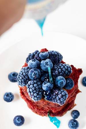 Blue topping pours on top of beetroot pancakes with blueberries and mulberries (Flip 2019)