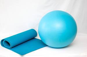 Blue Yoga Mat next to Blue Yoga Ball on White Background