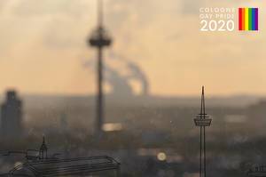Blurry background image of the city, next to picture title Cologne Gay Pride 2020, to celebrate LGBTQ und diversity