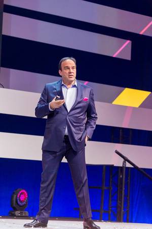 Body language during a keynote speech: Hagen Rickmann addresses the audience from the stage with an hand in his pocket