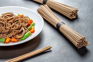 Boiled and raw buckwheat soba noodles on a black background (Flip 2019)