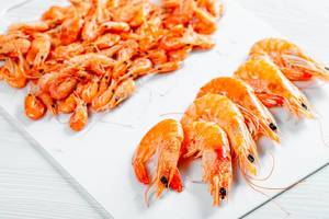 Boiled shrimp of different sizes on white background (Flip 2019)