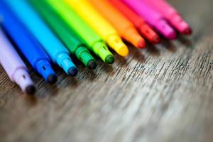 Bokeh Photo of colorful Highlighter next to each other on wooden table