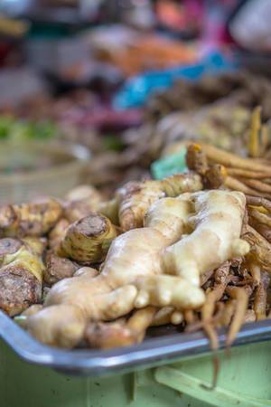 Bokeh Photo of Ginger surrounded by Carrots and other Vegetables