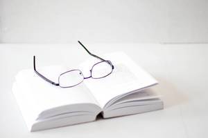 Book with Eyeglasses on a White Background